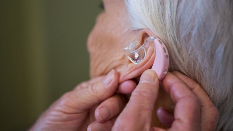 A woman is fitted with a hearing aid